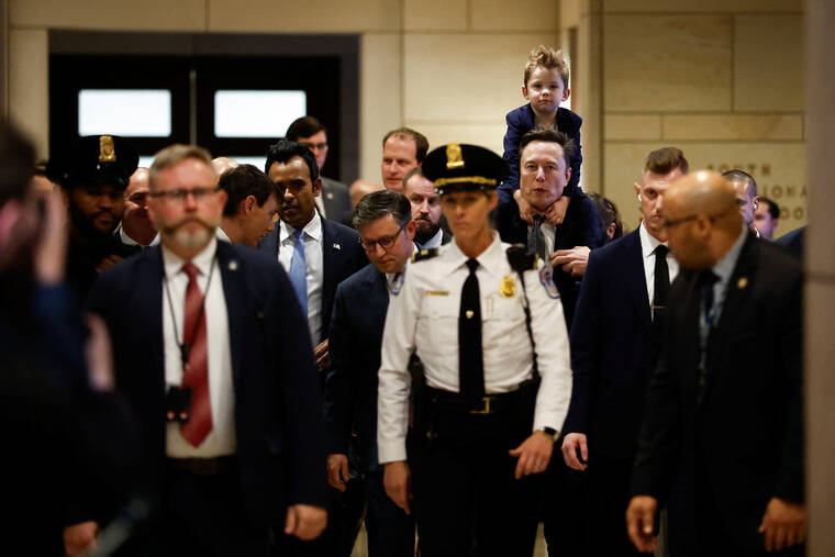 REUTERS/BENOIT TESSIER
                                Elon Musk and Vivek Ramaswamy, who are leading President-elect Donald Trump’s proposed new Department of Government Efficiency, walk on Capitol Hill accompanied by U.S. House Speaker Mike Johnson (R-LA), on the day of a meeting with members of Congress, as Musk holds his son on his shoulders, in Washington.