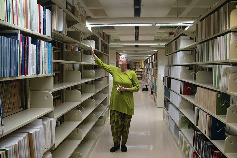 CRAIG T. KOJIMA / CKOJIMA@STARADVERTISER.COM.
                                Gwen Sinclair, department chair and librarian for government documents and maps at Hamilton Library, pointed out Monday how high floodwaters rose in the government documents collection area during the 2004 flood. Tons of documents, maps and irreplaceable documents were lost.