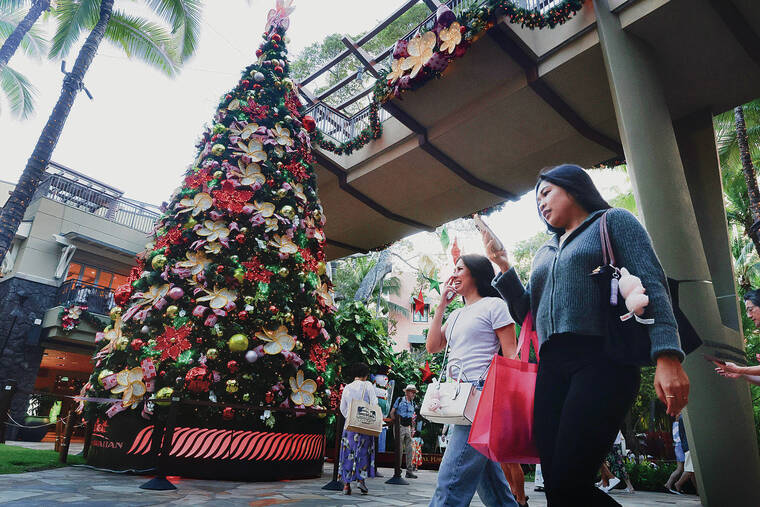 GEORGE F. LEE / GLEE@STARADVERTISER.COM
                                Shoppers browsed amid the holiday decor and the Christmas tree at the Royal Hawaiian Shopping Center in Waikiki on Monday.