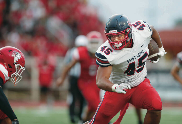 JAMM AQUINO / AUG. 10
                                Saint Louis tight end Pupualii Sepulona (45) rushes the ball against the Kahuku Red Raiders after a reception during the first half of a high school football game in Kahuku.