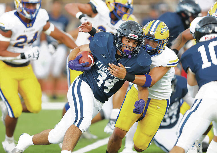 JAMM AQUINO /JAQUINO@STARADVERTISER.COM
                                Kamehameha-Maui running back Kaikea Hueu (34) gets around Kaiser defensive back Kash Kamauoha (12) during the first half of the 2024 HHSAA Division II football championship on Saturday in Mililani.